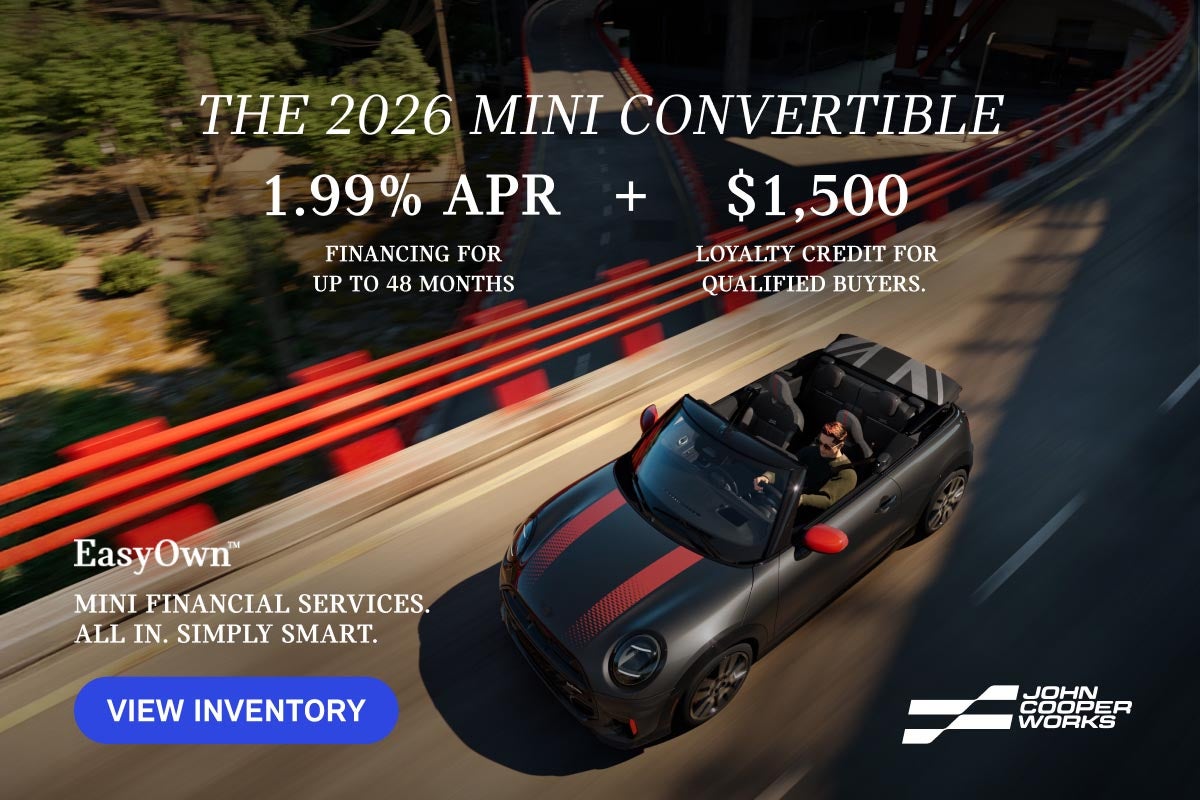 Plano aéreo de un MINI JCW Cabrio circulando por una autopista elevada.