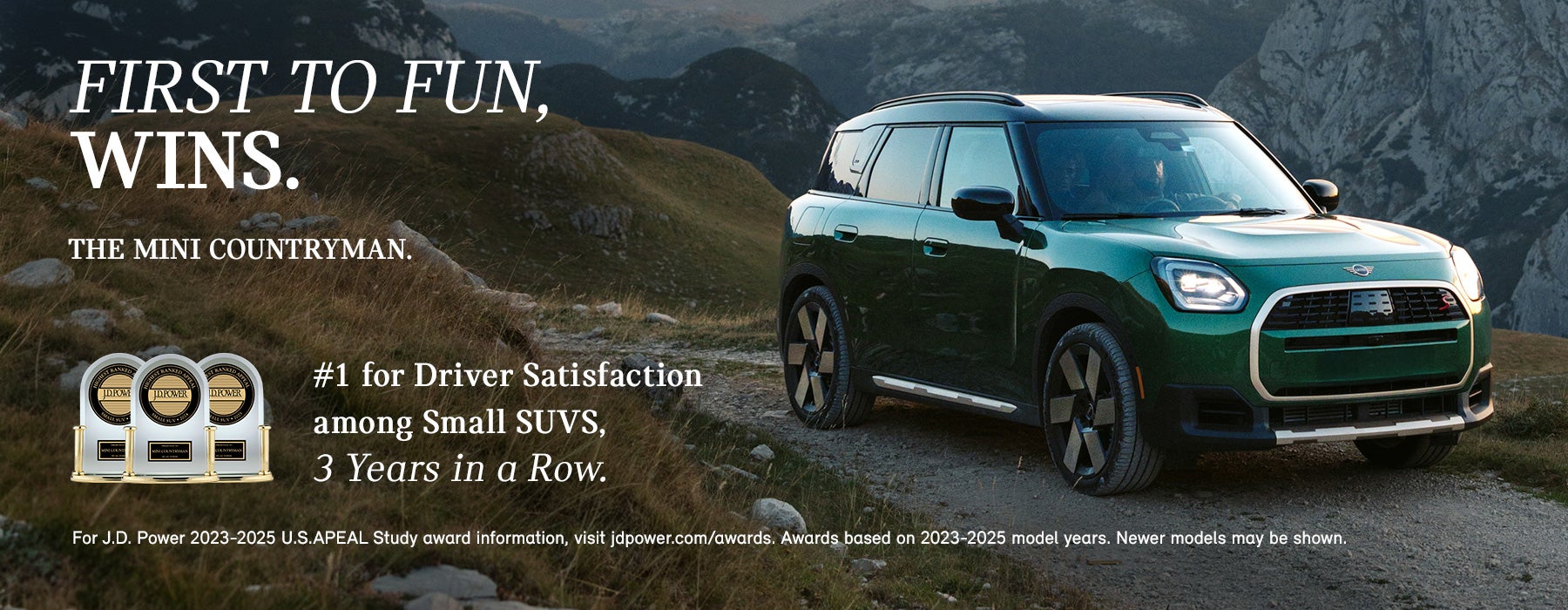 Vista lateral del lado del acompañante de un MINI Countryman verde circulando por una carretera de montaña.
