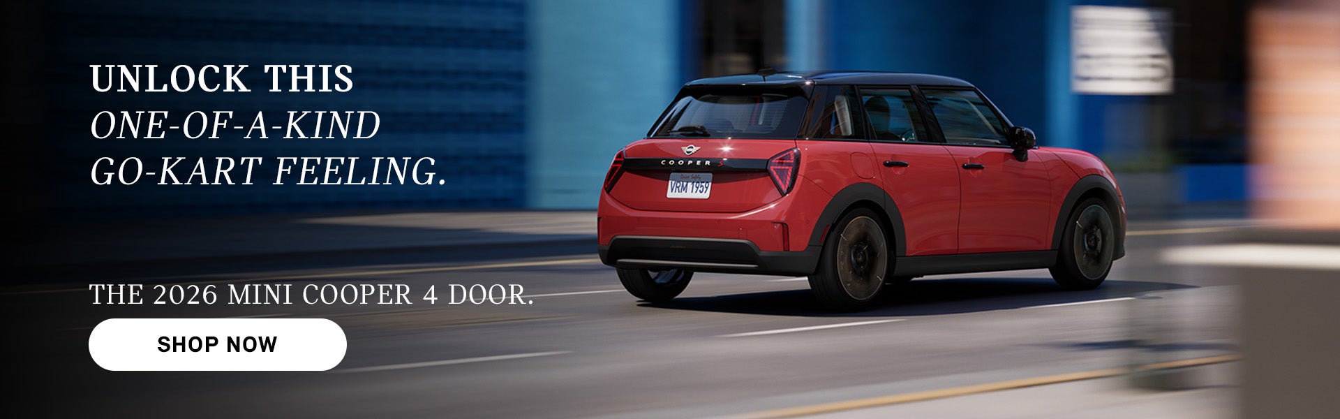 Un MINI Cooper rojo de cuatro puertas circulando por una calle de la ciudad, con un efecto de desenfoque de movimiento al fondo y un texto publicitario que promociona el modelo de 2026 y 