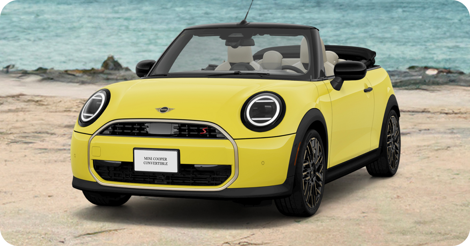 Vista frontal del MINI Cooper Convertible amarillo aparcado en la playa.