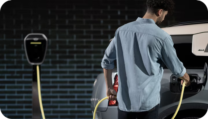 Un hombre carga su MINI Countryman SE ALL4.