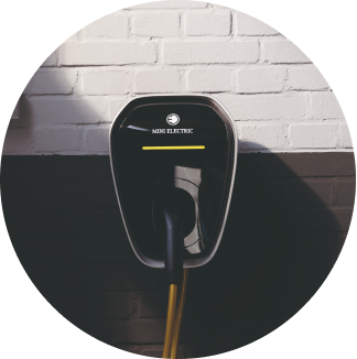 El cargador MINI Wallbox en una pared de ladrillo partido en blanco y negro.