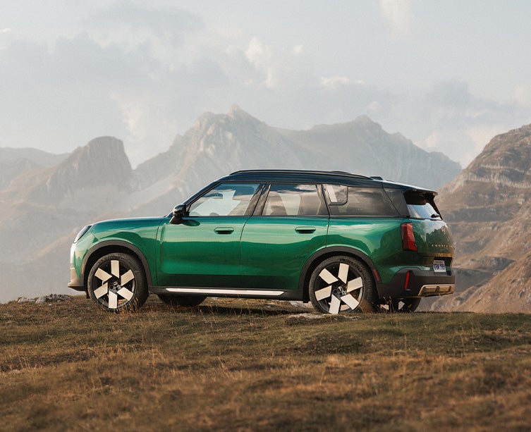Foto de perfil lateral de un MINI Countryman en color «British Racing Green». 