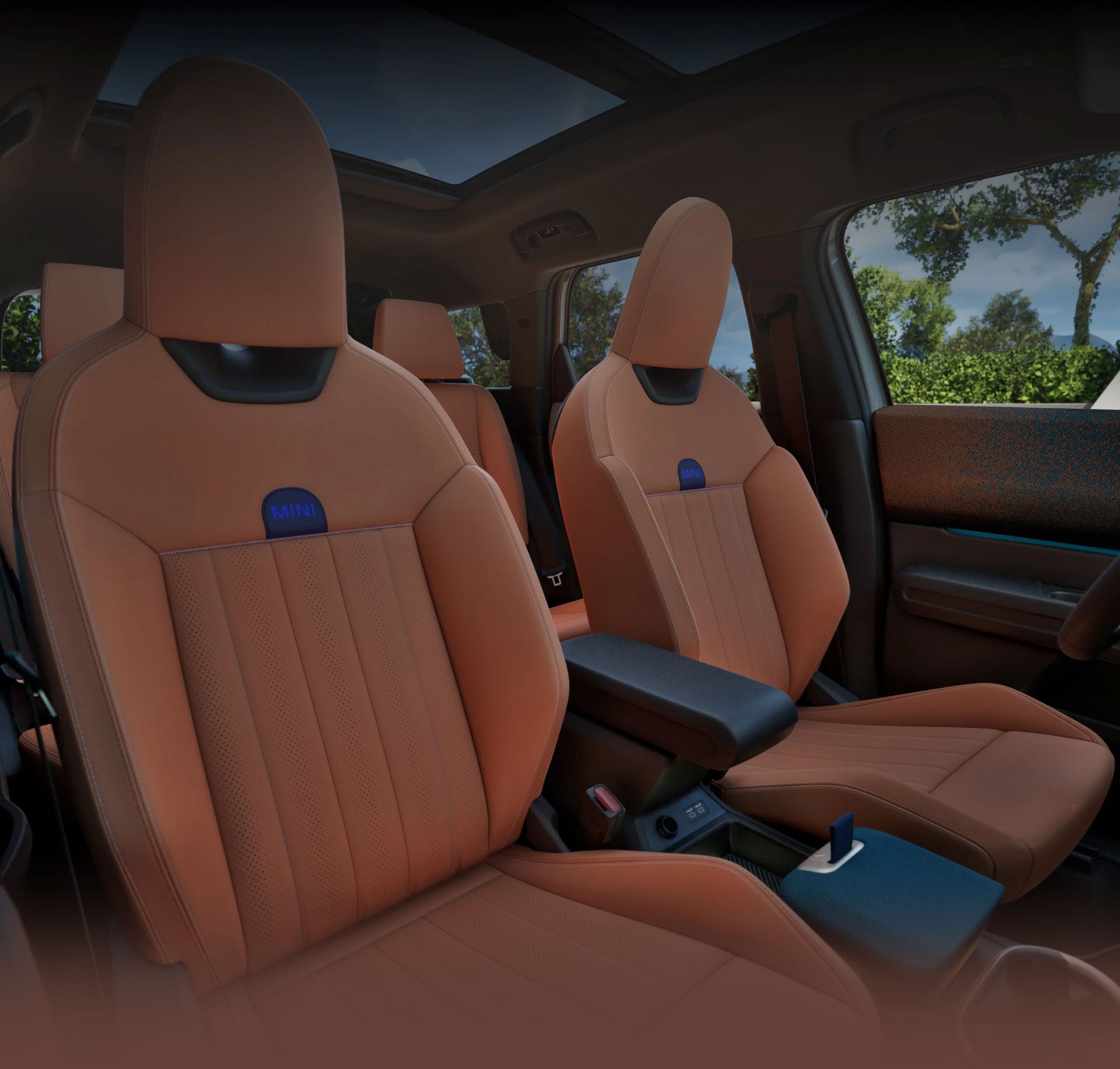 ountryman S ALL4 tomada desde el lado del pasajero mostrando los asientos deportivos delanteros con cielos azules y árboles por las ventanillas.