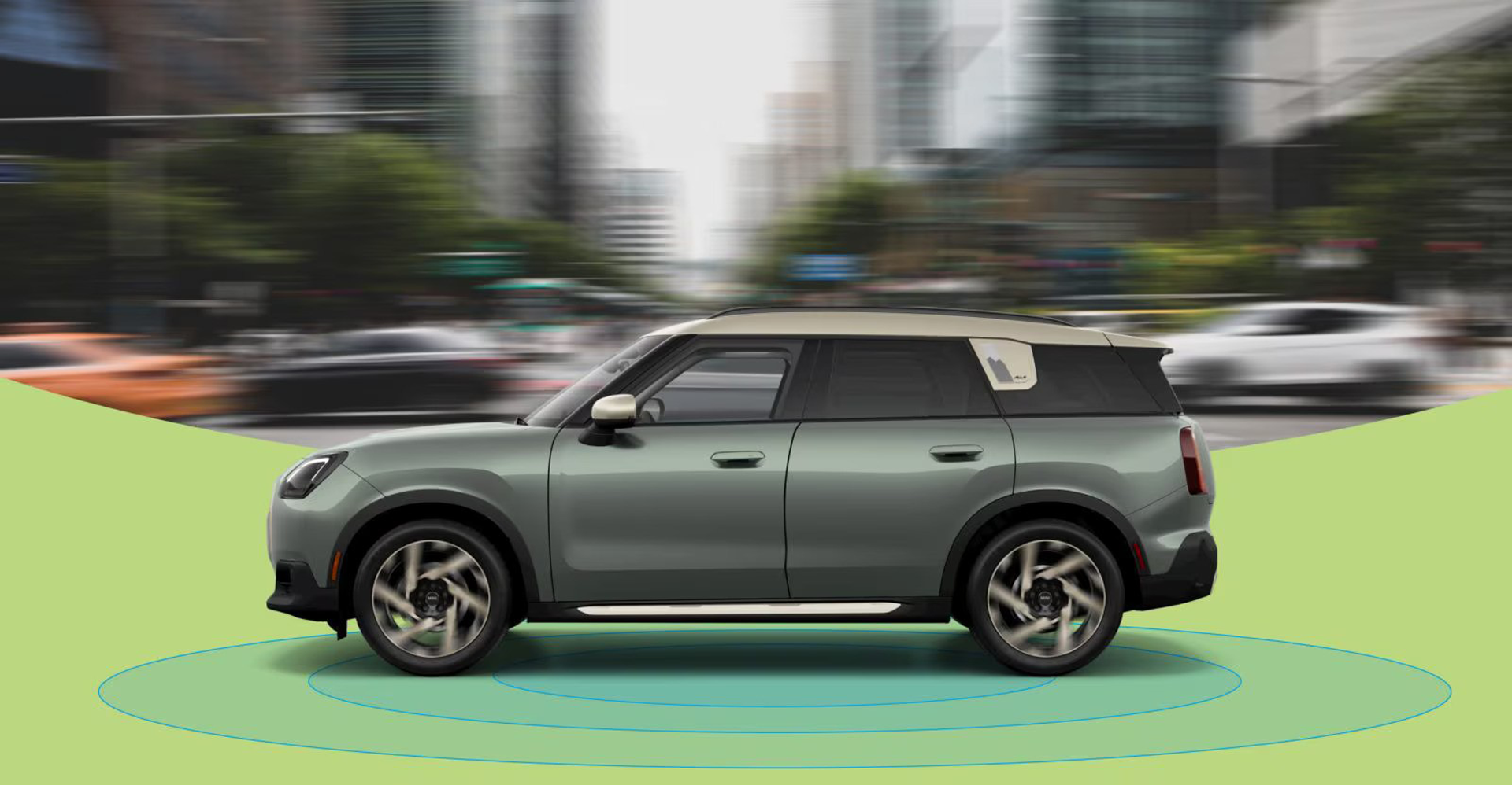 La vista lateral de un MINI Countryman S ALL4 de 2025 con una calle urbana borrosa de fondo y anillos azules debajo.