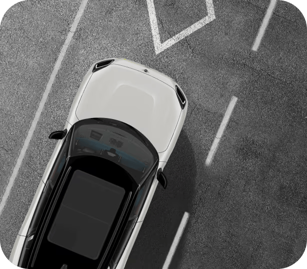 Vista aérea de un vehículo MINI blanco con techo blanco aparcado en una acera con líneas de carril blancas a cada lado del vehículo.