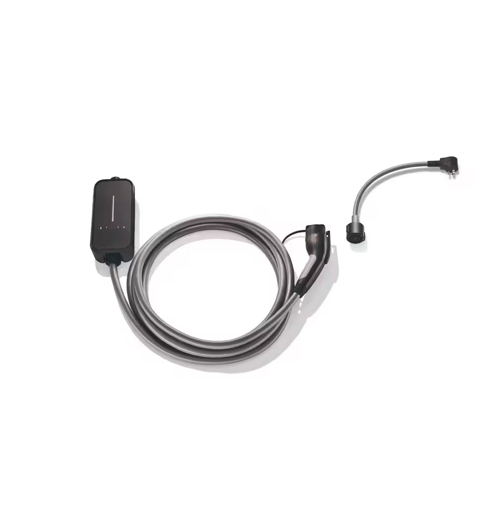 Enchufe eléctrico en una pared blanca con un cargador MINI Electric enchufado.