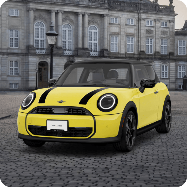 Vista en ángulo del MINI Cooper Oxford Editon aparcado en una zona adoquinada.