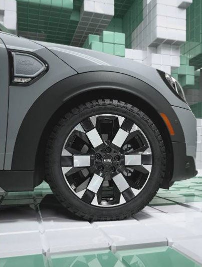 Primer plano de las exclusivas llantas de 18" Untamed spoke 2-tone en un MINI Countryman Untamed Edition, en un mundo CGI formado por cajas 3D, tipo Tetris.